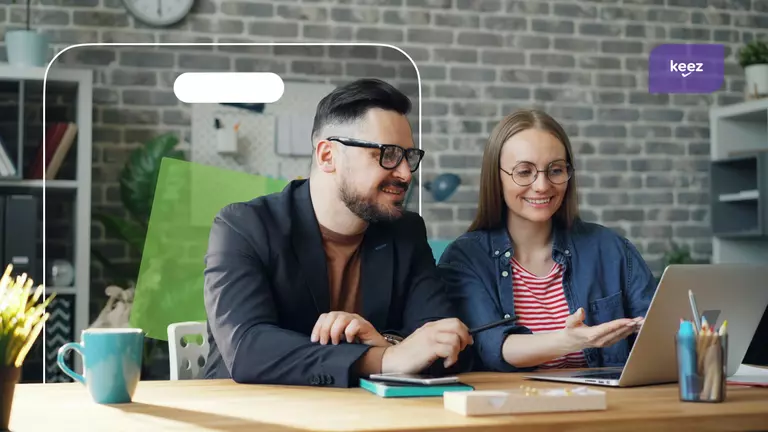 un barbati si o femeie se uita la un laptop
