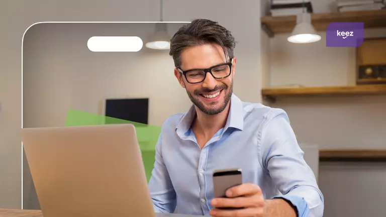 Comunicare contabil: bărbat se uită la telefon zâmbind