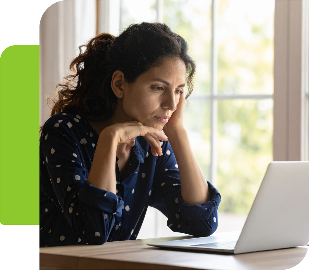 Femeie care se uită neliniștită la monitor